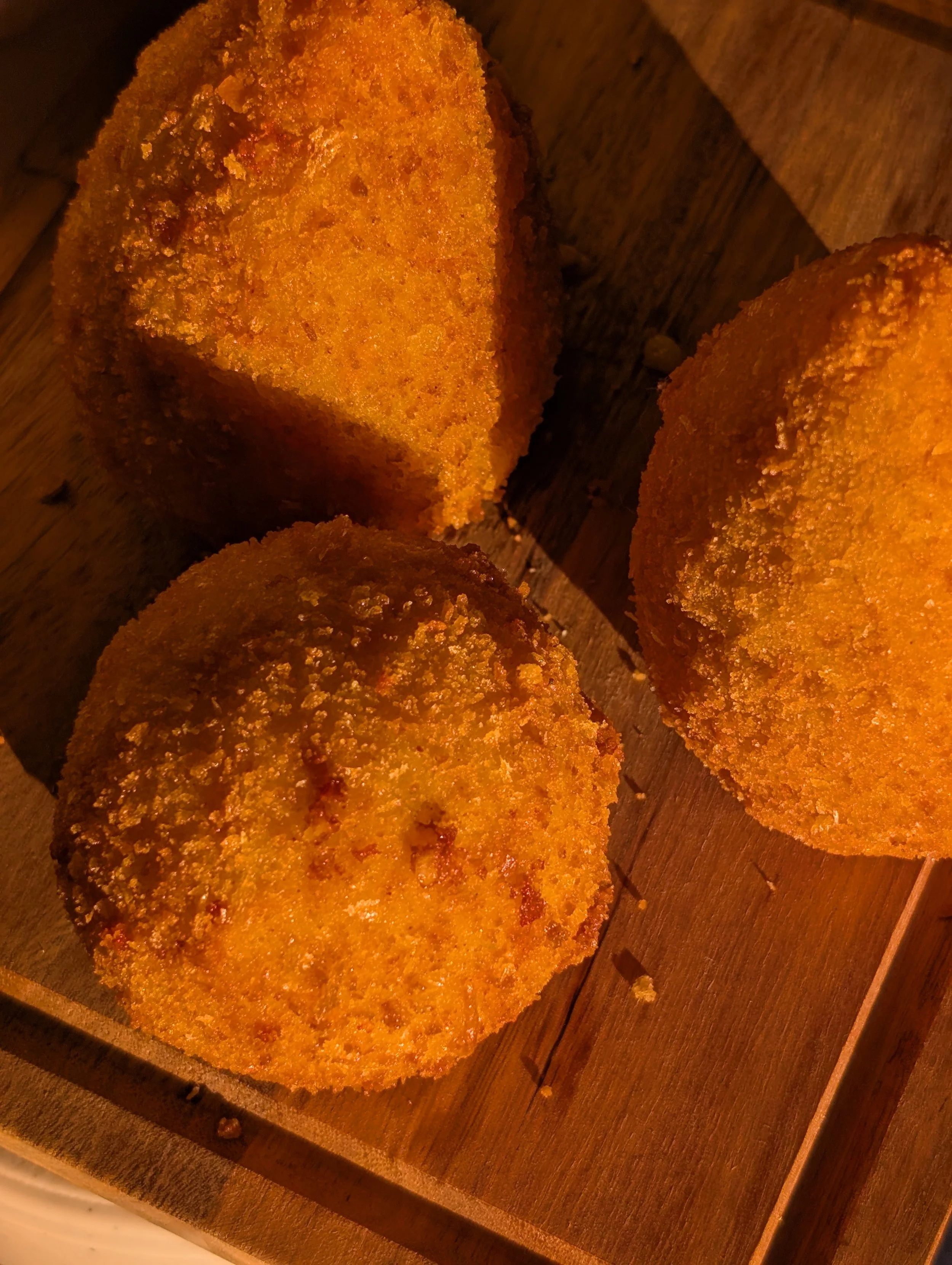 Golden arancini on a wooden serving board