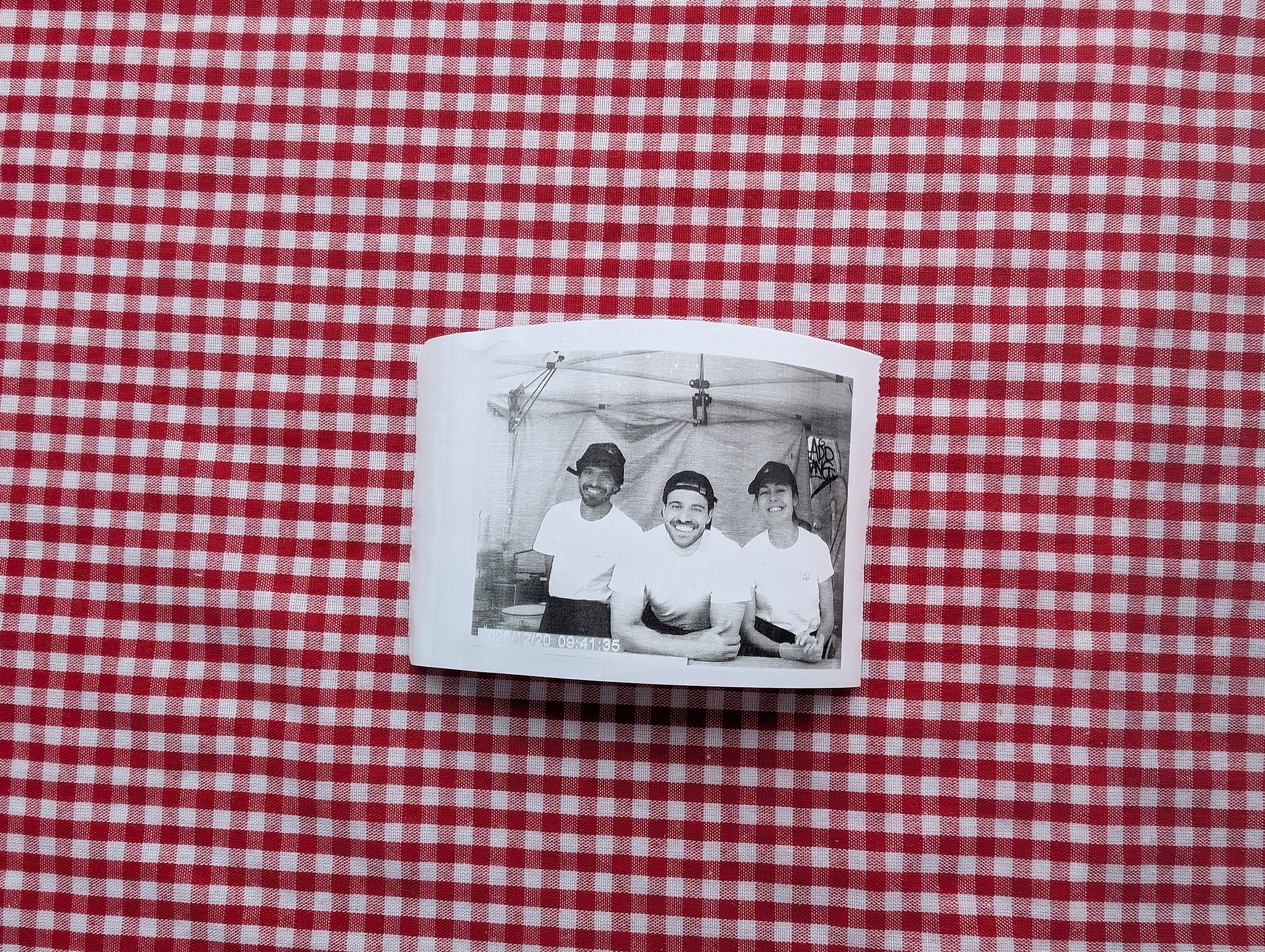 An old family photo resting on a gingham tablecloth