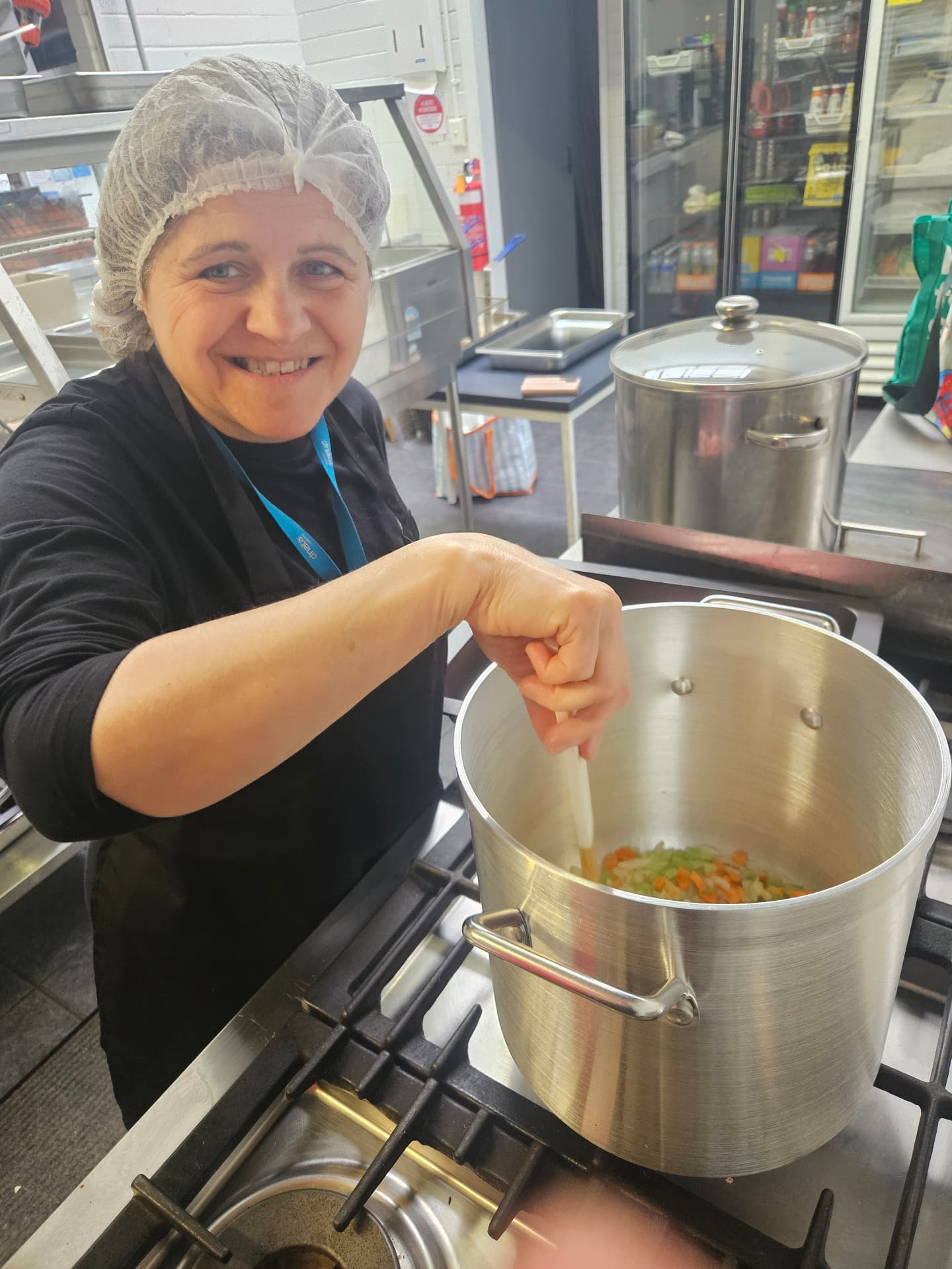 Carmela stirring a pot in the kitchen